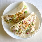round plate with celery chicken salad wrapped in flour tortilla