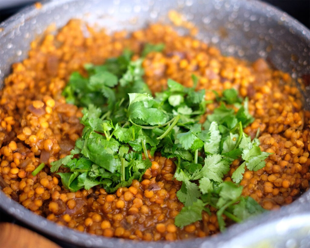 Saute pan with cooked lentils and cilantro.