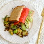 roasted pepper sandwich with sliced avocado and roasted brussels sprouts