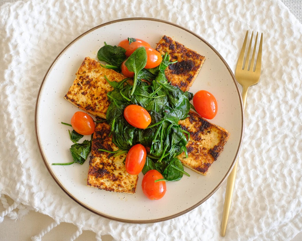 easy recipe - pan-fried tofu topped with sauteed spinach and cherry tomatoes.