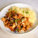white round plate with moroccan chicken and couscous.