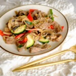 round plate with thin slice beef stir fry with red bell pepper, zucchini, and bean sprouts