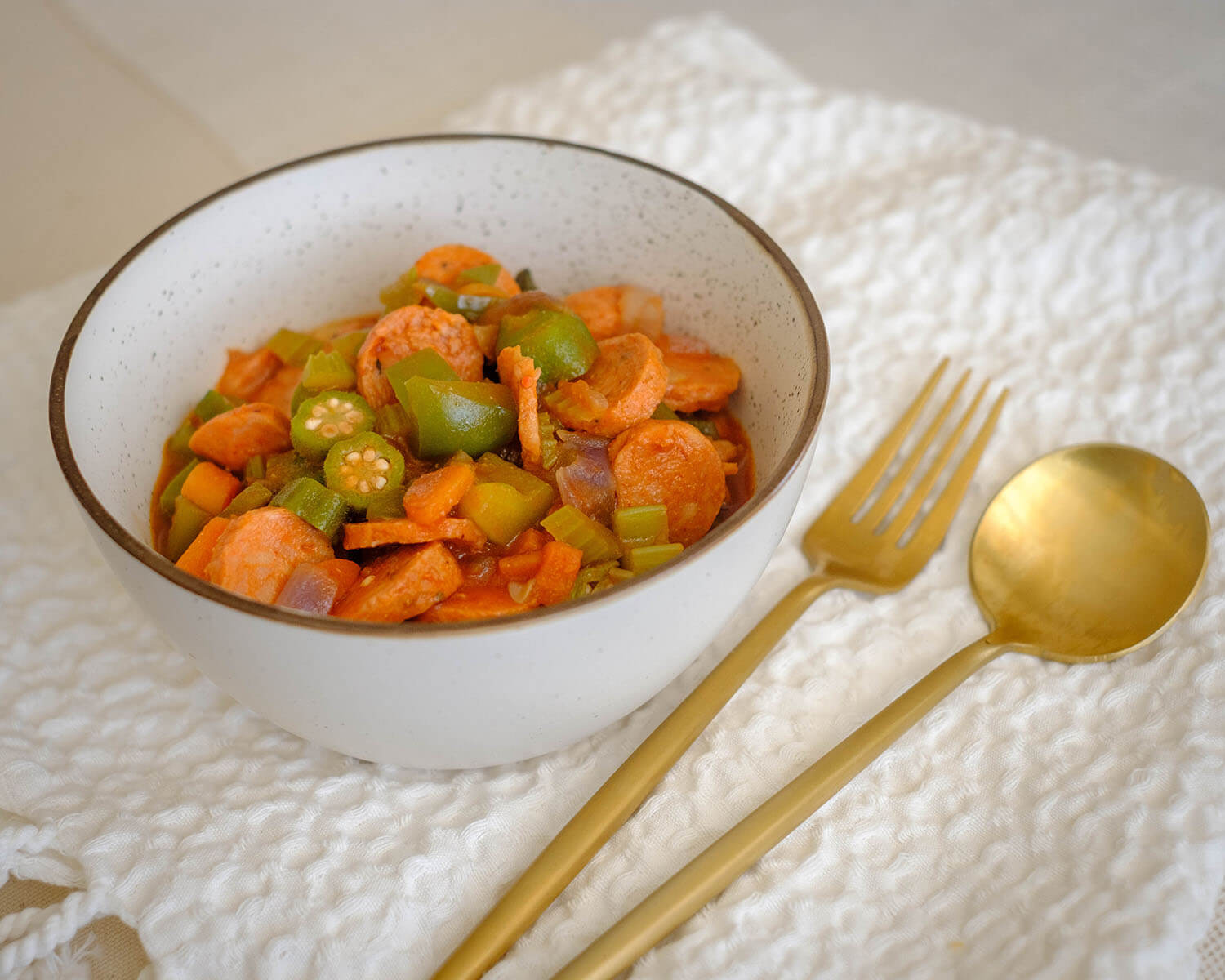 round bowl with sausage, celery, okra, in a tomato stew