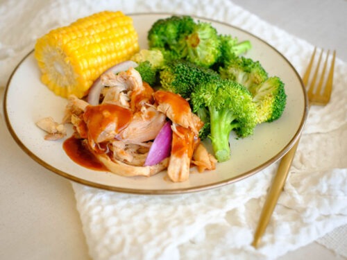 Round plate with shredded bbq chicken, corn, and broccoli