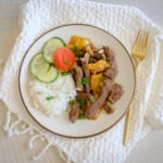 Round plate with rice, beef, cucumber and tomato