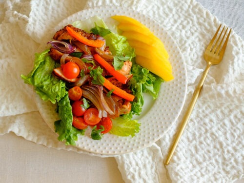 round plate with chicken fajita lettuce wrap and sliced mango