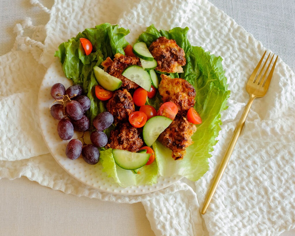 round plate with chicken meatball lettuce wraps served with grapes, healthy lunch idea