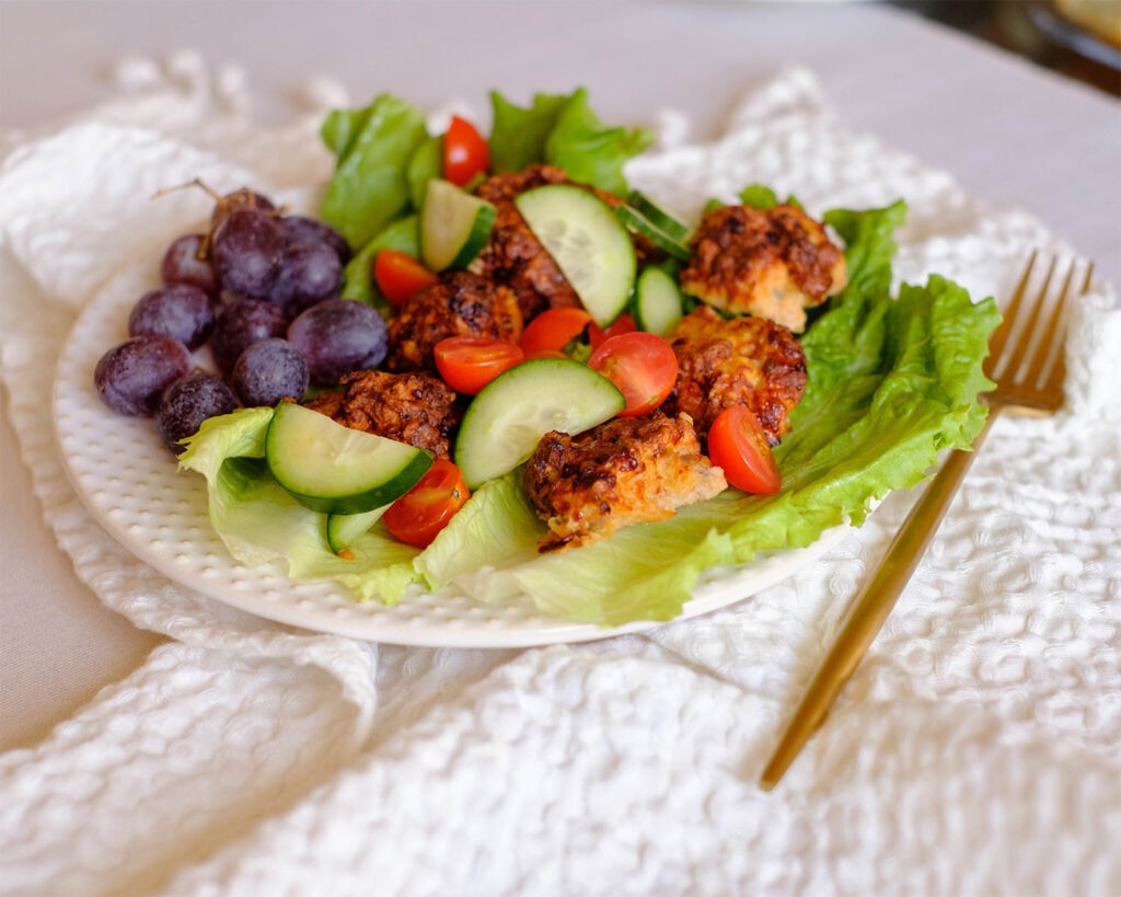 round plate with chicken meatball lettuce wraps served with grapes, healthy lunch idea