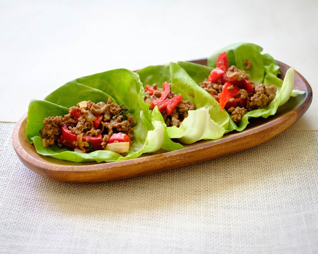 asian beef lettuce wraps on a wooden bowl