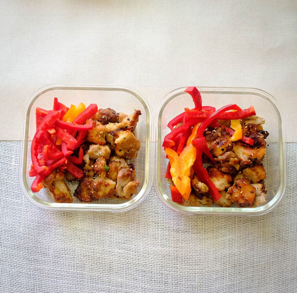 Glass meal prep container with chicken and red bell peppers - try this air fryer chicken recipe