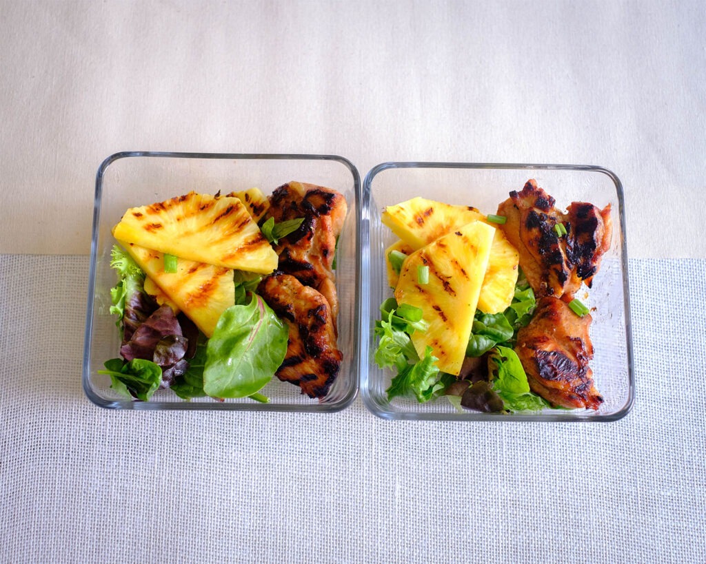 round plate with grilled chicken with grilled pineapple and crisp greens