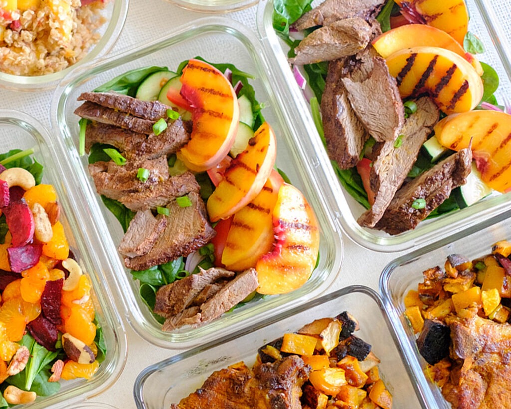 grilled peach and steak salad in meal prep containers