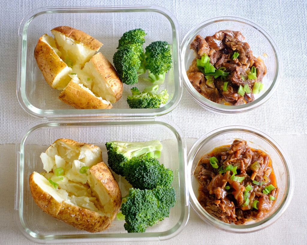 Glass meal prep container with instant pot beef and baked potato and broccoli