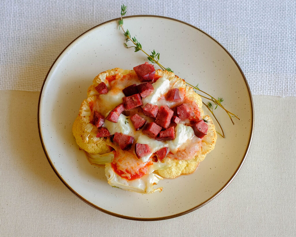 round plate with cauliflower sausage pizza