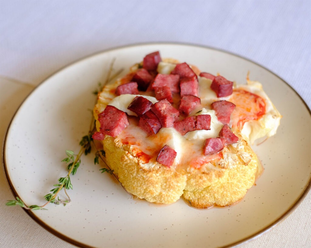 round plate with cauliflower sausage pizza