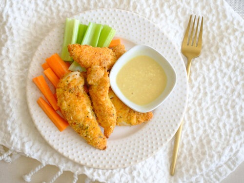 round plate with panko breaded chicken tenders and carrots and celery and honey mustard