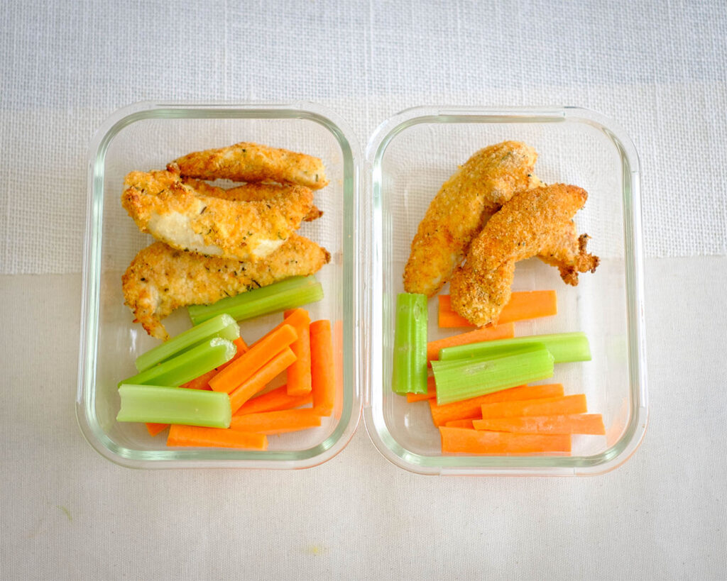 glass meal prep containers with panko breaded oven baked chicken tenders and carrots and celery