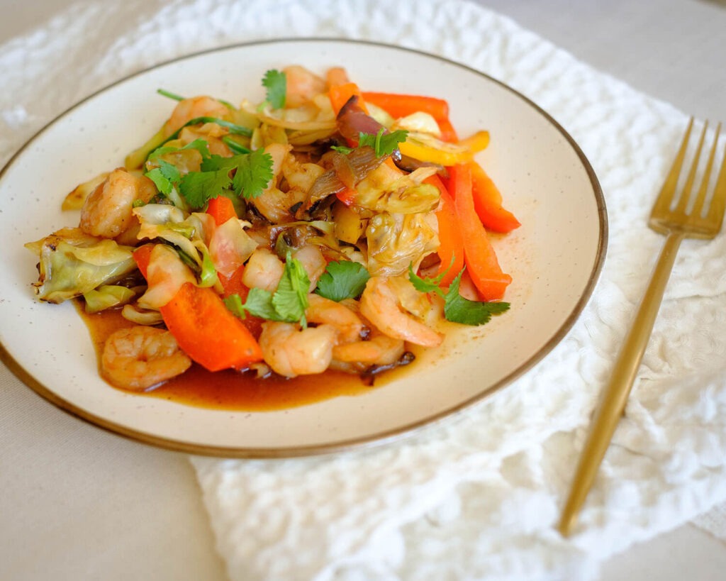 shrimp and cabbage stir fry on a plate ready to eat