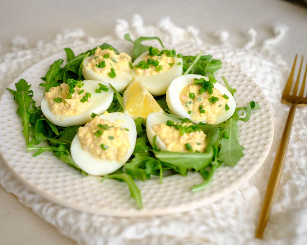 round plate with deviled eggs and arugula salad for a low carb meal