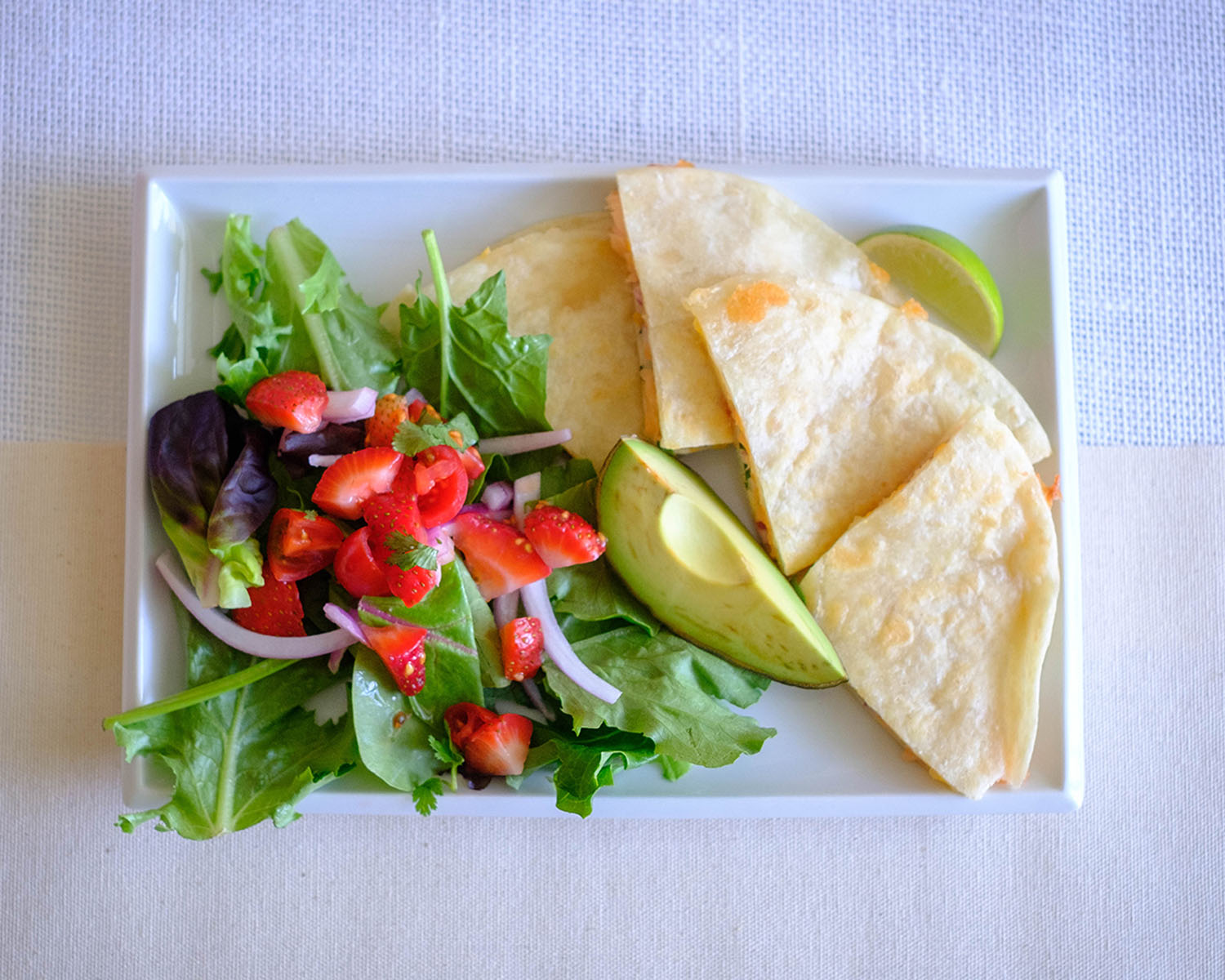 plate with salmon quesadilla and strawberry salsa salad