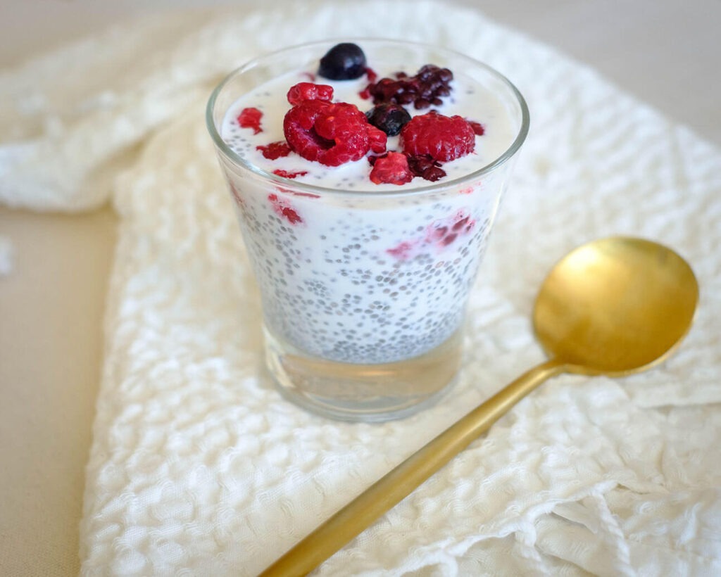 glass cup with chia pudding topped with mixed berries for a healthy breakfast