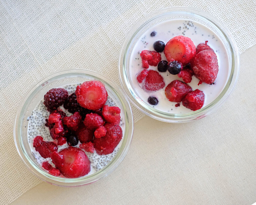 glass cups with chia pudding topped with mixed berries for a health breakfast