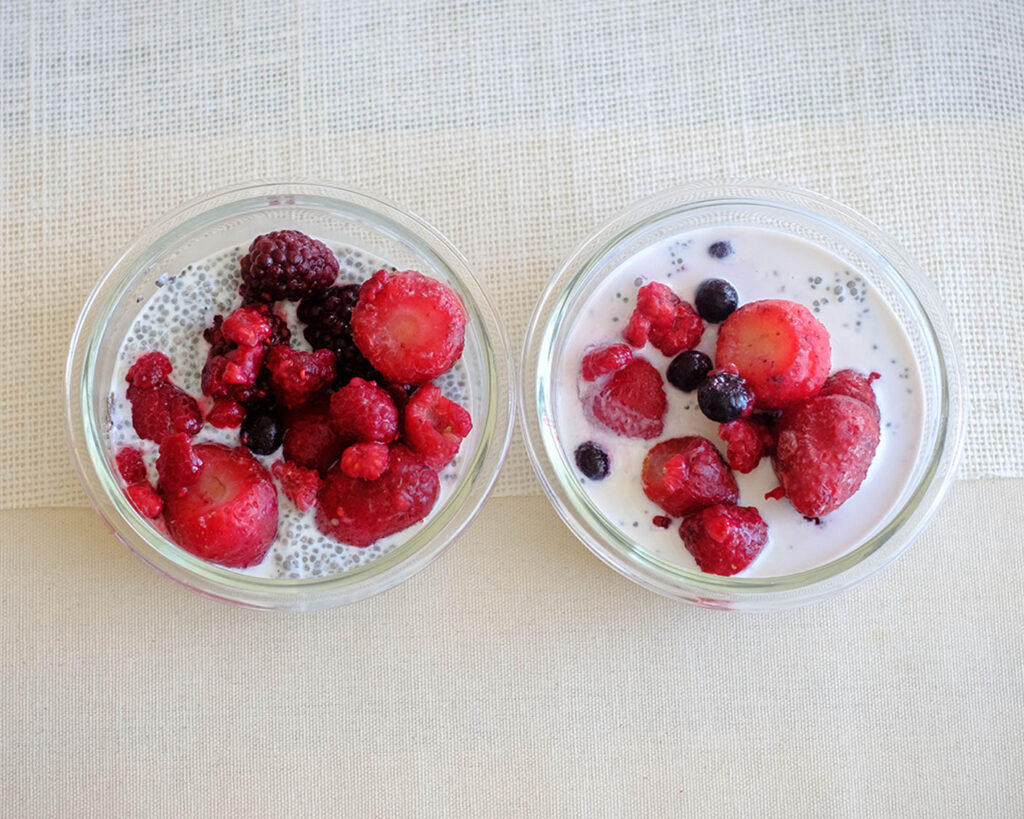 glass cups with chia pudding topped with mixed berries for a healthy breakfast