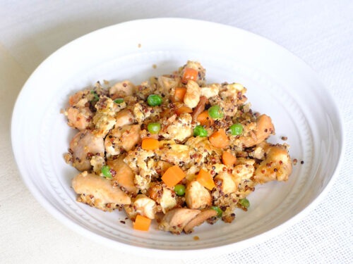 round plate with chicken, quinoa, scrambled eggs, peas, and carrots