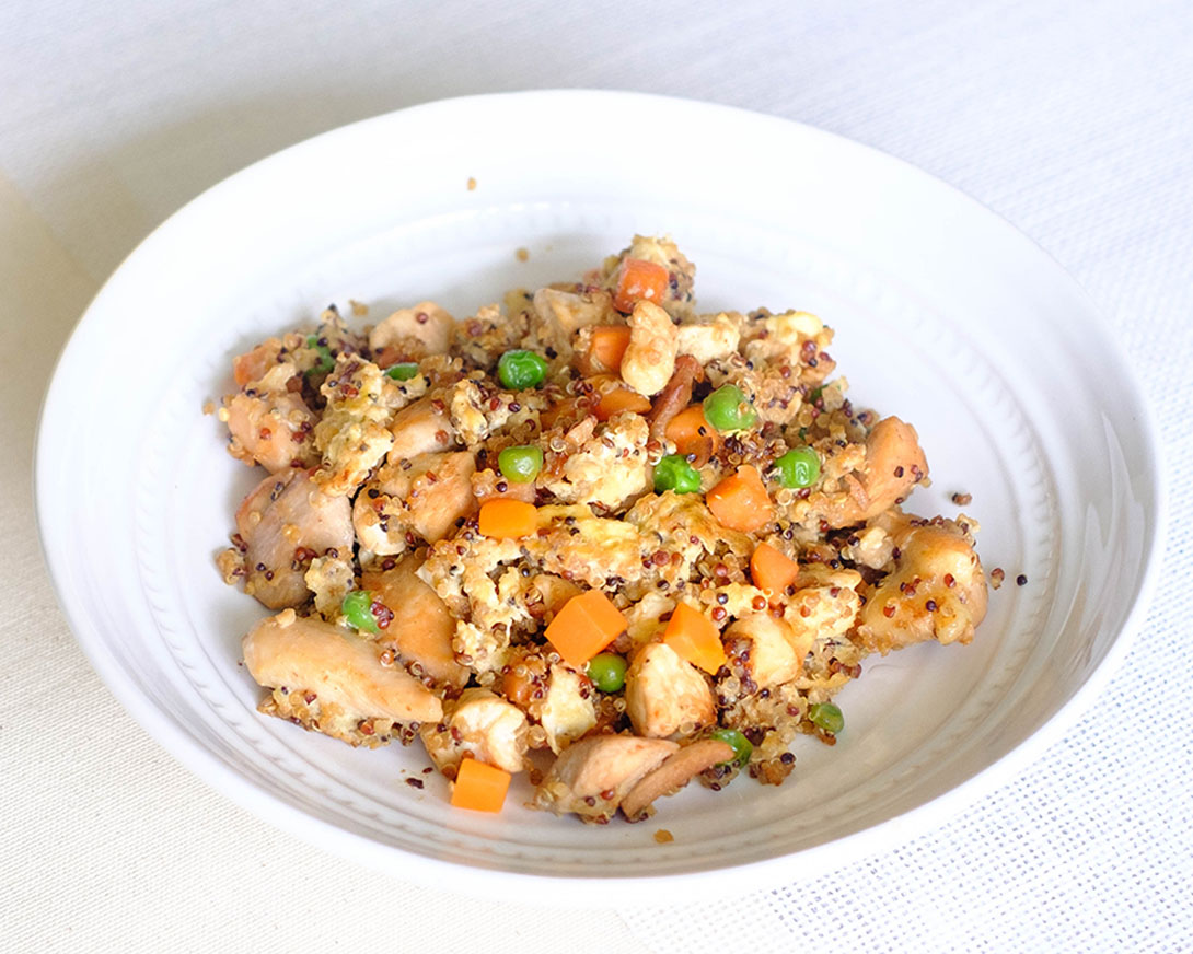 round plate with chicken, quinoa, scrambled eggs, peas, and carrots