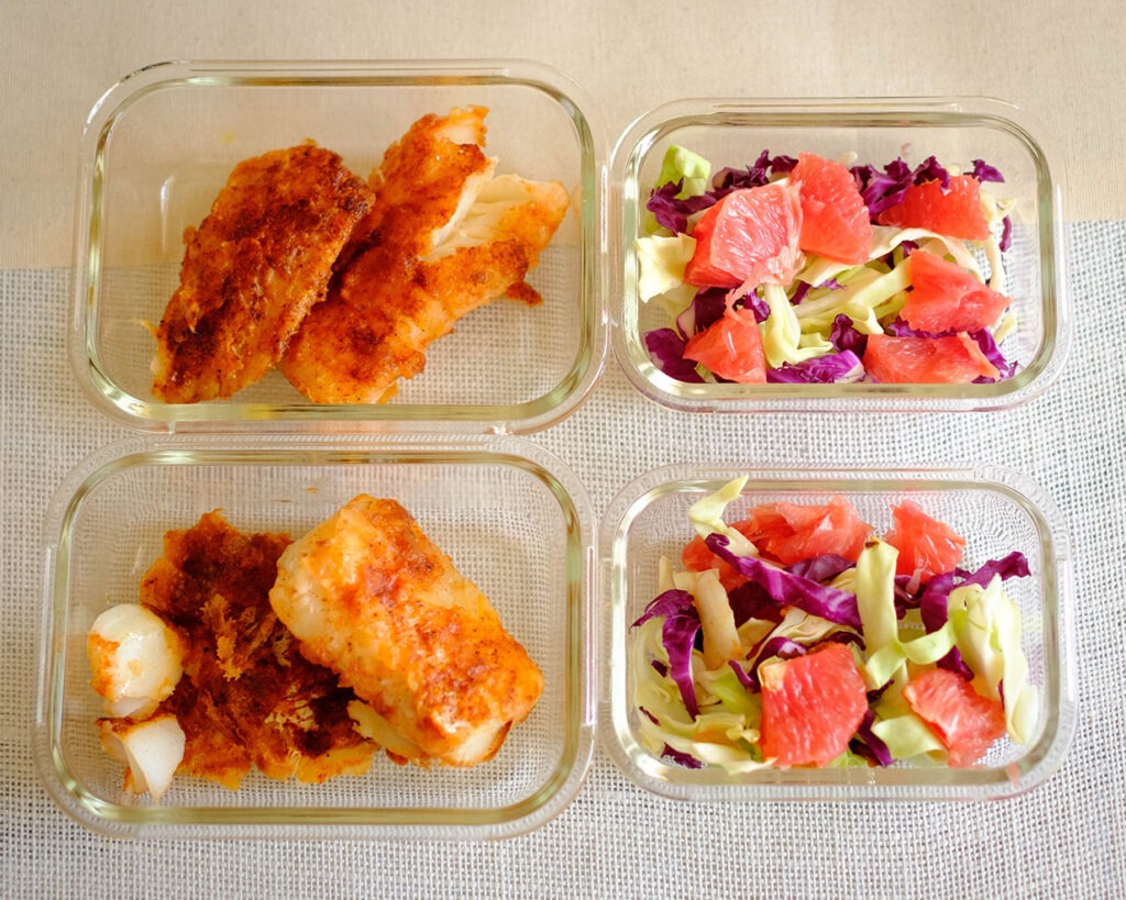 Glass meal prep containers with fish recipe of chile rubbed cod and grapefruit coleslaw