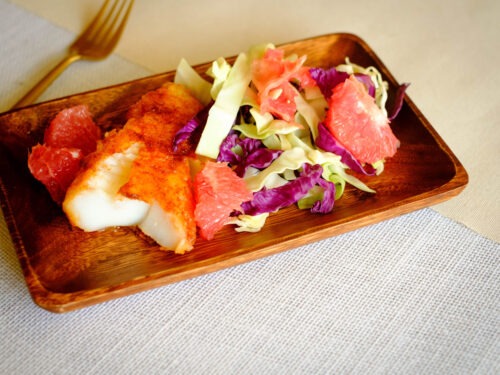 rectangular wooden plate with chile rubbed cod and grapefruit coleslaw