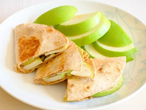 round plate with peanut butter quesadillas and sliced green apples