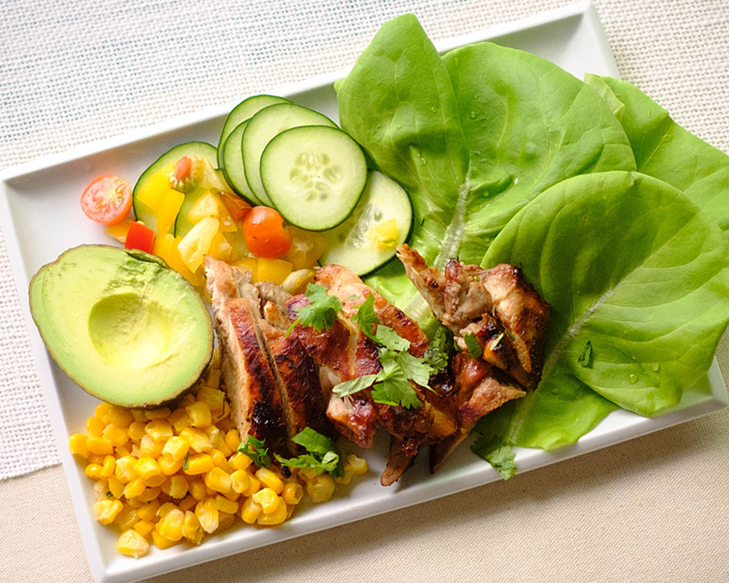 rectangle plate with corn, avocado, grilled chicken, cherries, cucumbers, and lettuce