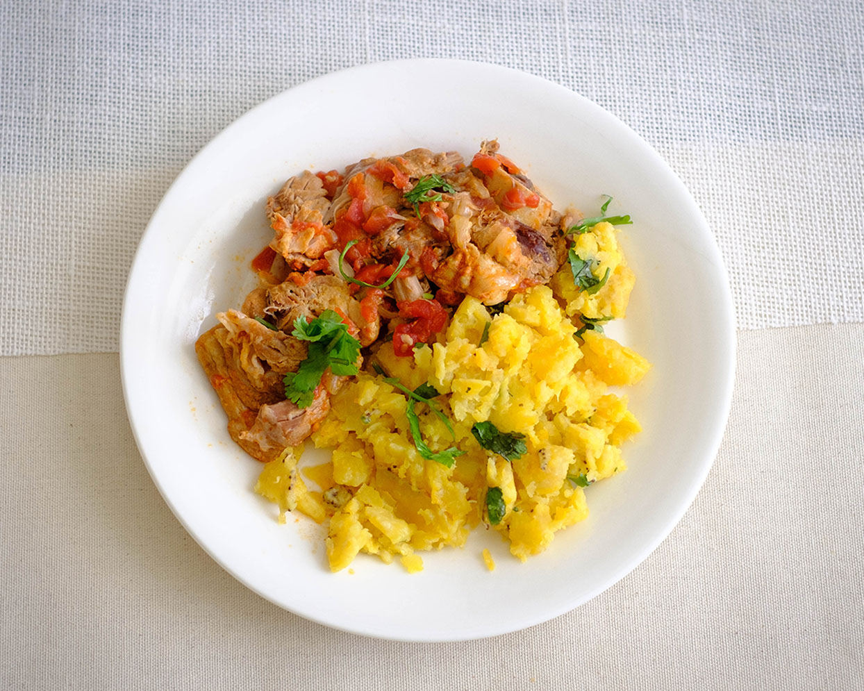 round plate with shredded pork with mashed plaintains