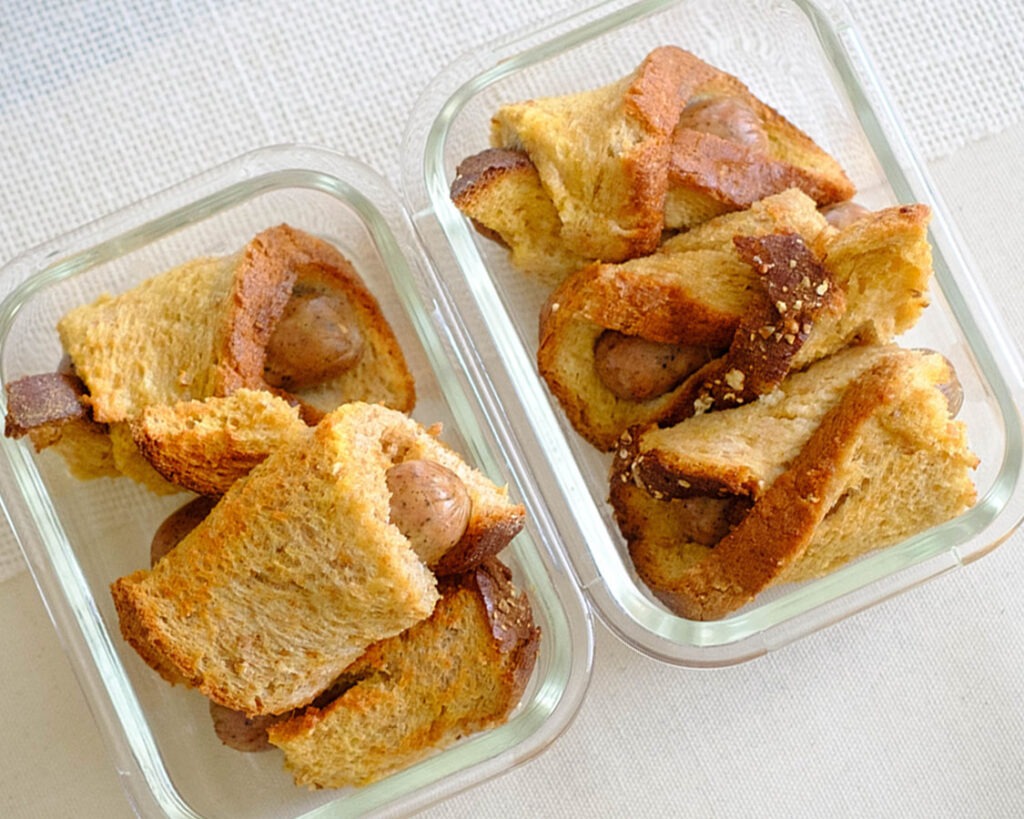 meal prep containers with sausage rolled up in french toast