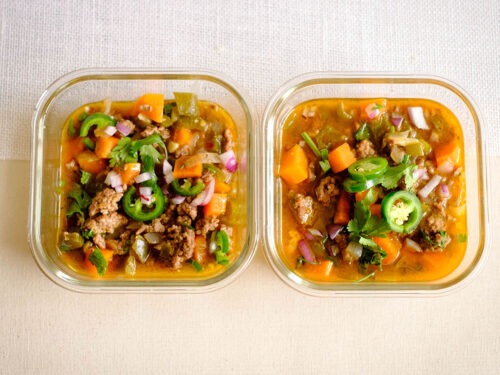 glass meal prep containers that have ground beef, sweet potatoes, green bell peppers, cilantro, jalapeno, and red onions