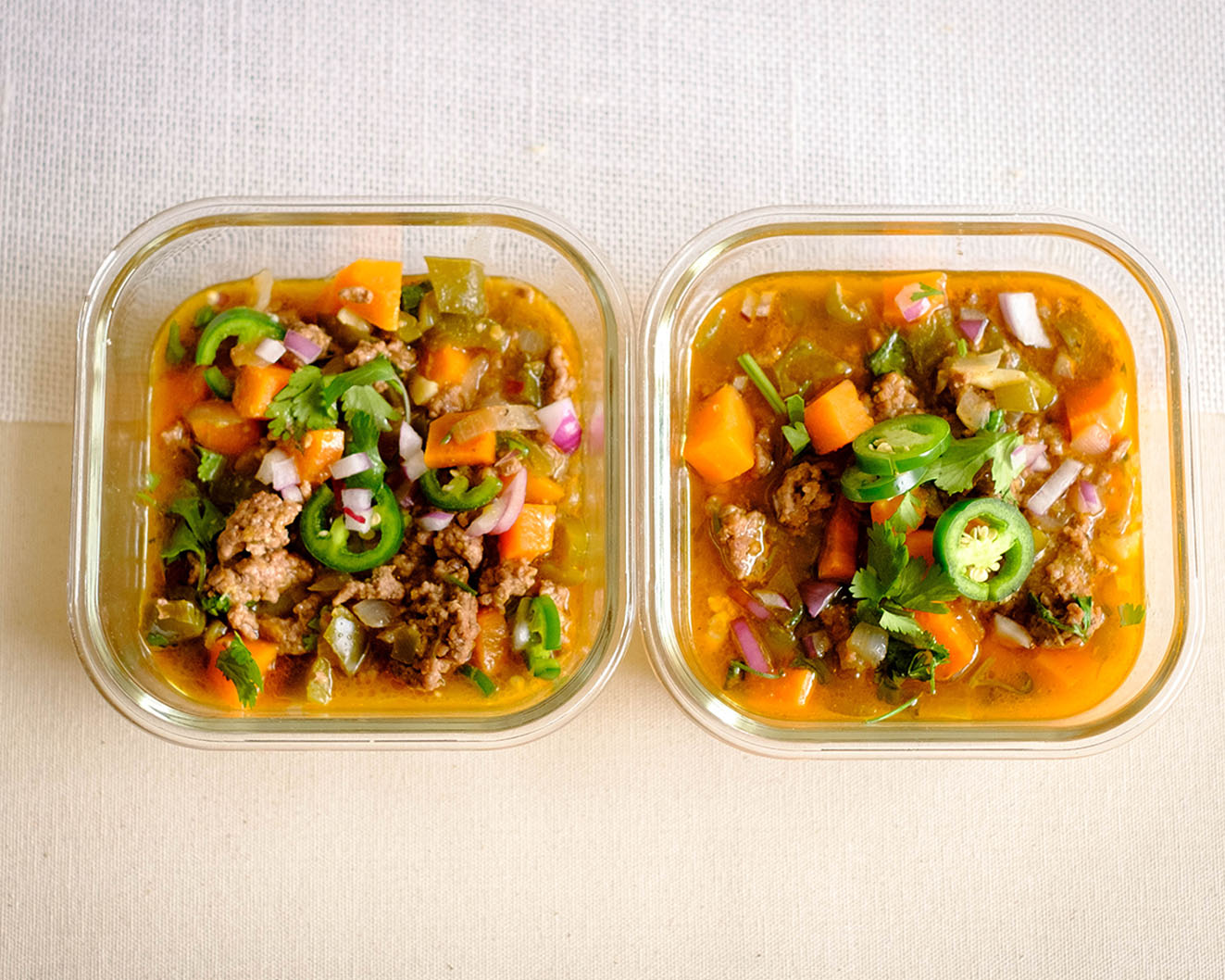 glass meal prep containers that have ground beef, sweet potatoes, green bell peppers, cilantro, jalapeno, and red onions