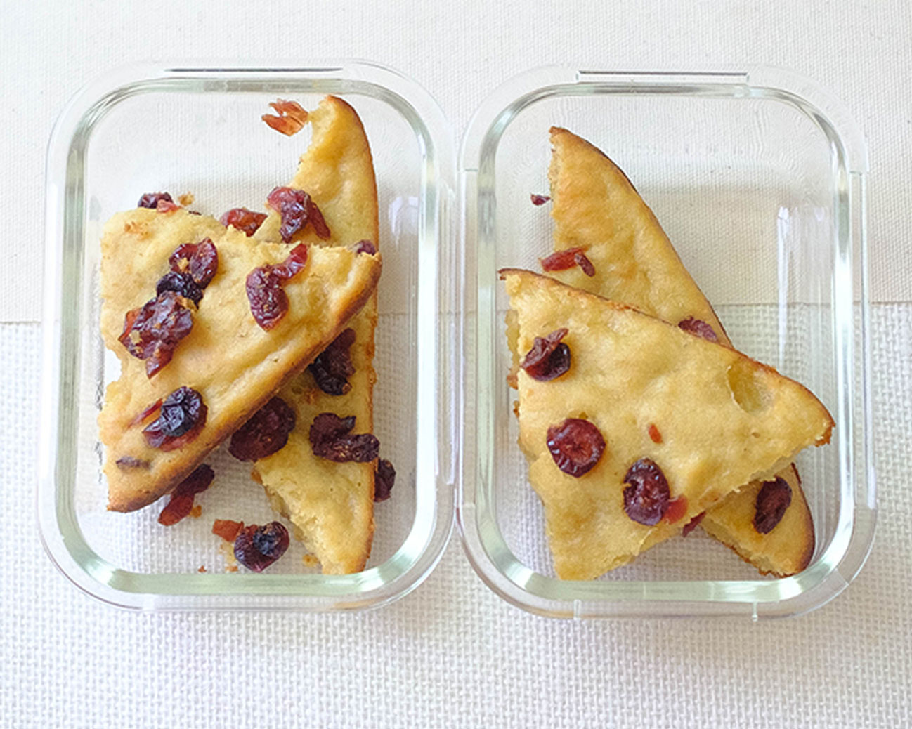 rectangular glass meal prep containers with cranberry applesauce muffin bars