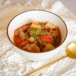 round bowl with basil beef stew with diced tomatoes and potatoes