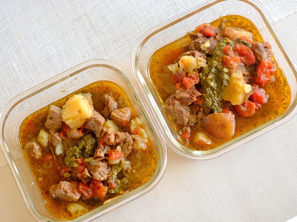 glass meal prep containers with basil beef stew with diced tomatoes and potatoes