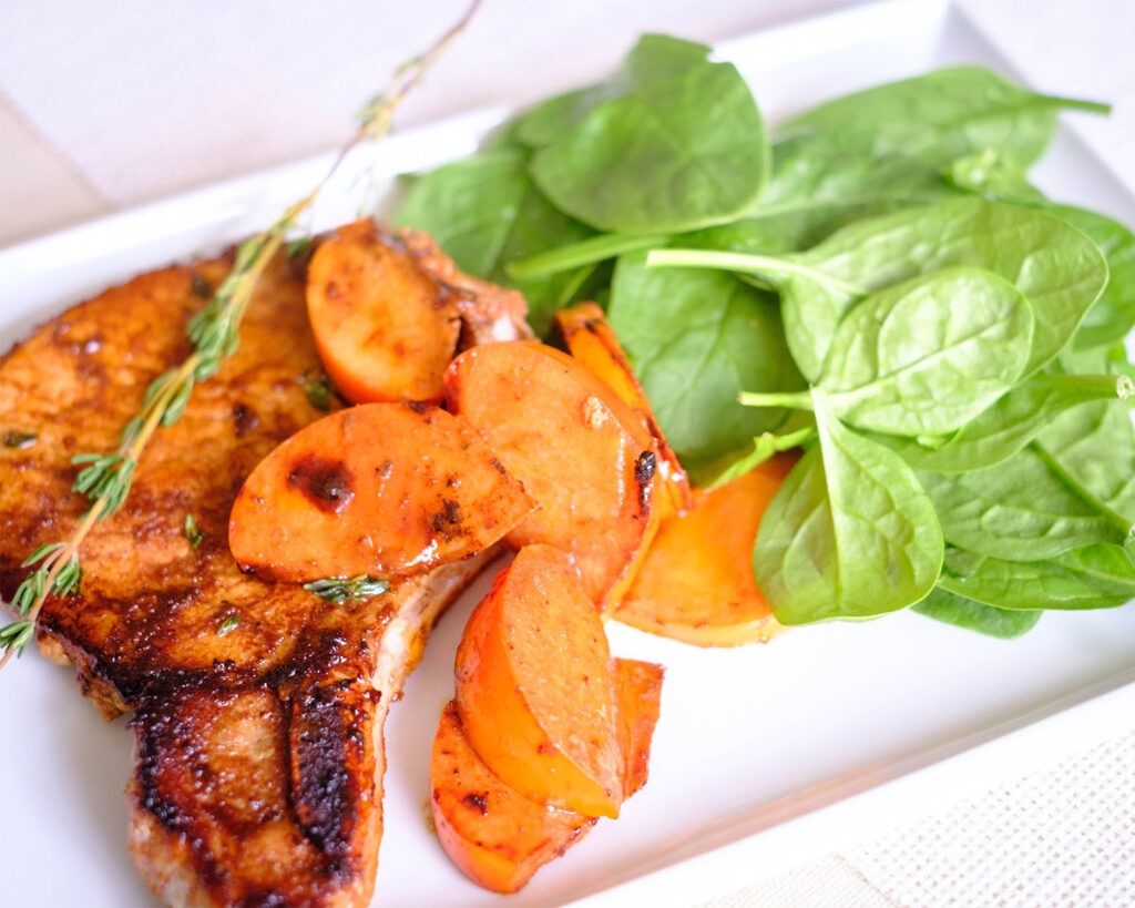 pork meal prep of balsamic glazed porkchops with persimmons and baby spinach