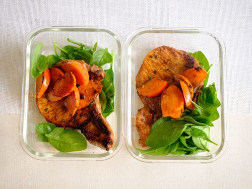 glass meal prep containers with balsamic glazed porkchops with persimmons and baby spinach