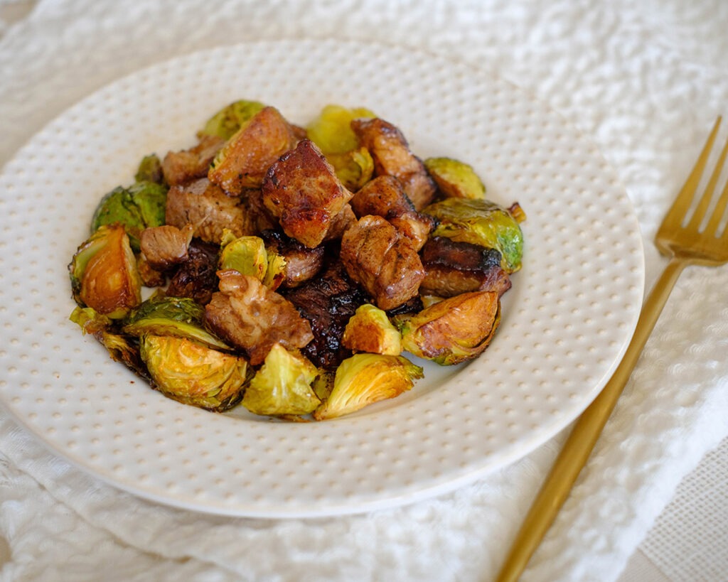 round plate with steak cubes and brussel sprouts