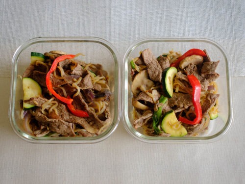 glass square containers with sliced beef stir fry with bell peppers, sliced zucchini, and sliced mushrooms, and bean sprouts
