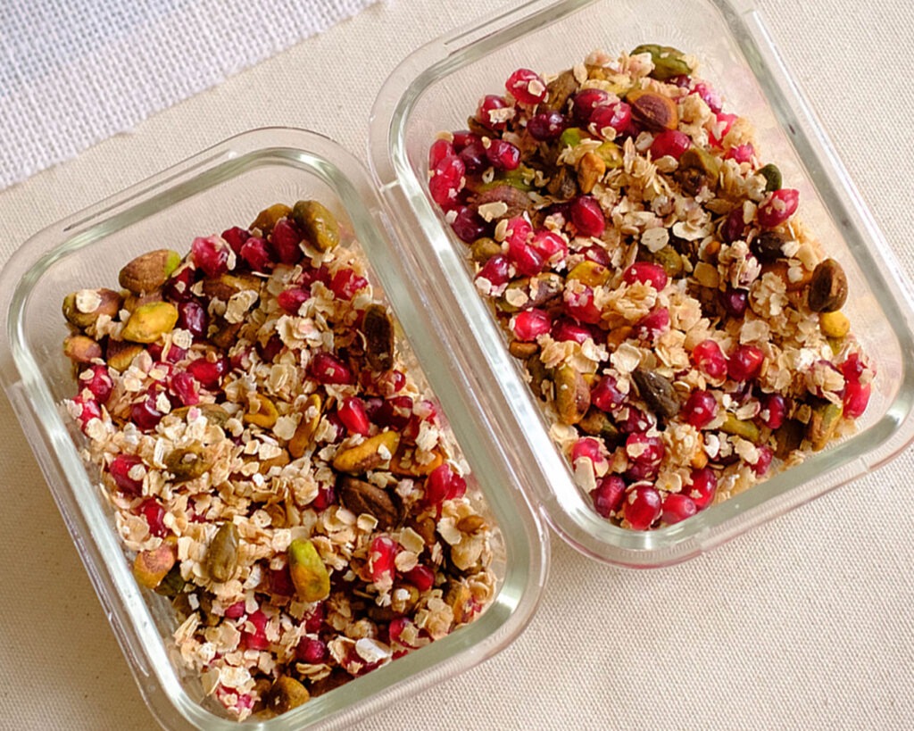 rectangular glass meal prep container with pistachios, pomegranate, and rolled oats