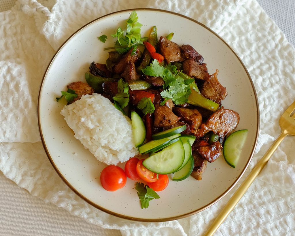 round plate with pork stir fry and vegetables with white rice