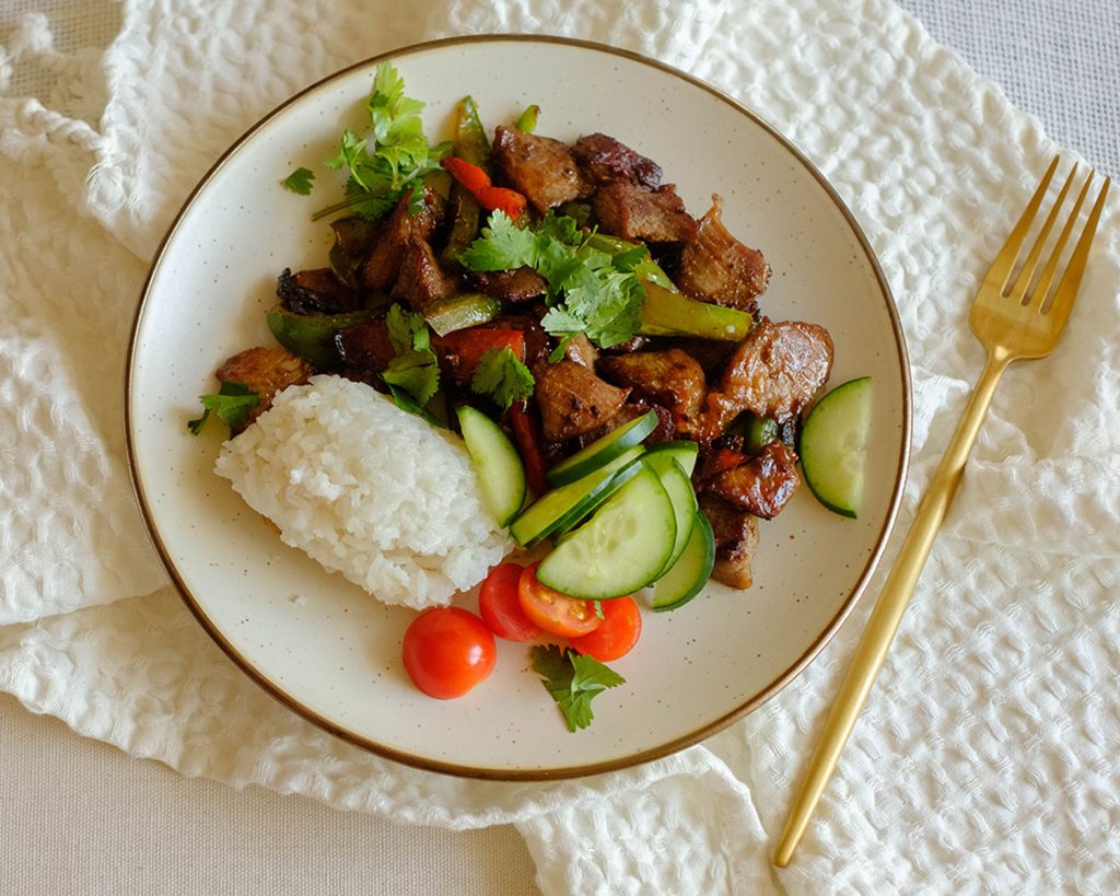 round plate with pork stir fry and vegetables with white rice