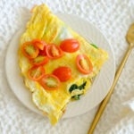 round plate with omelette topped with eggs