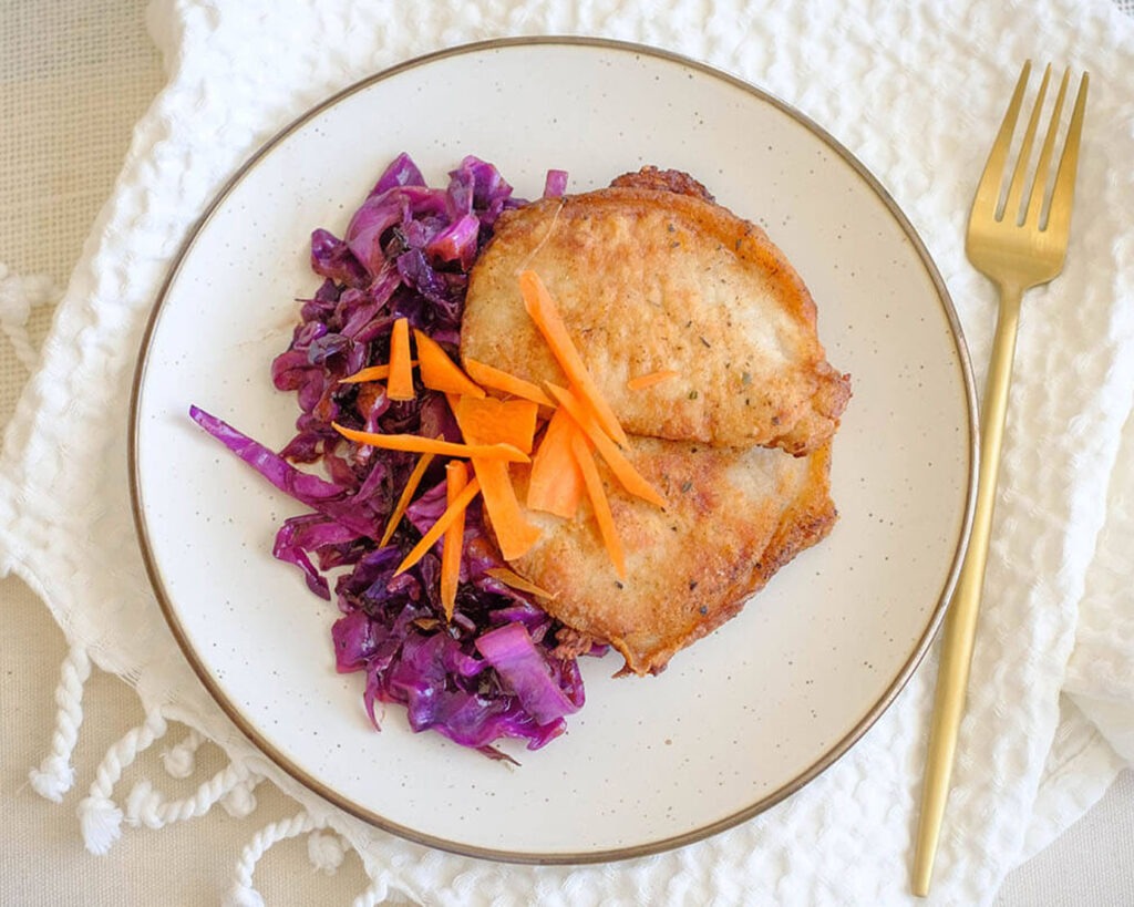 round plate with pork chops and sauteed red cabbage