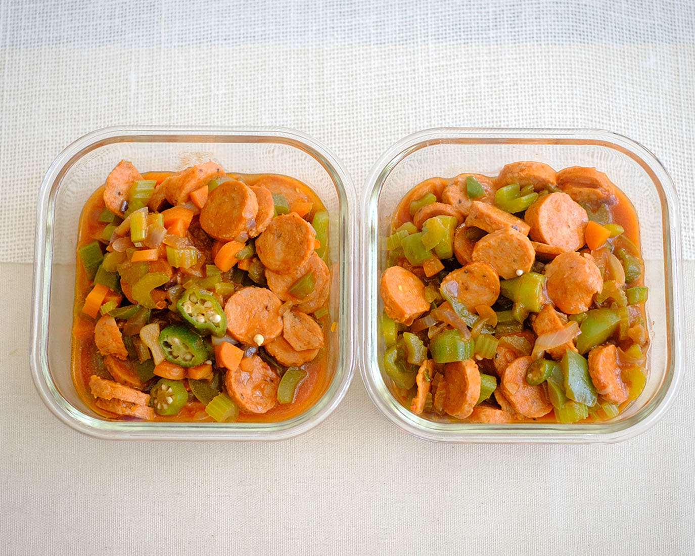 square meal prep containers with cajun sausage stew in tomato sauce with okra and green bell peppers